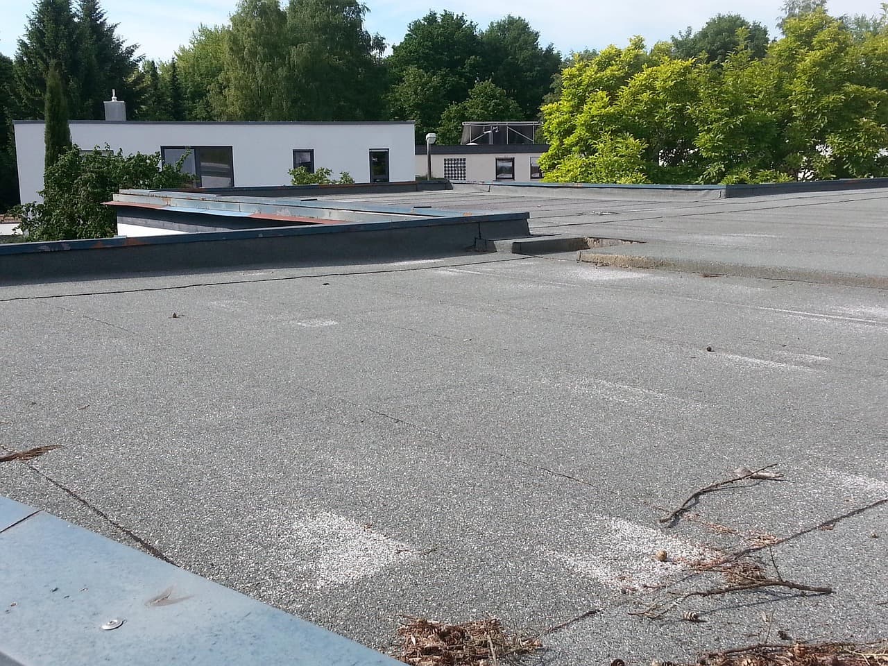 Flachdach mit Bitumenabdichtung und Attika an einem Wohnhaus