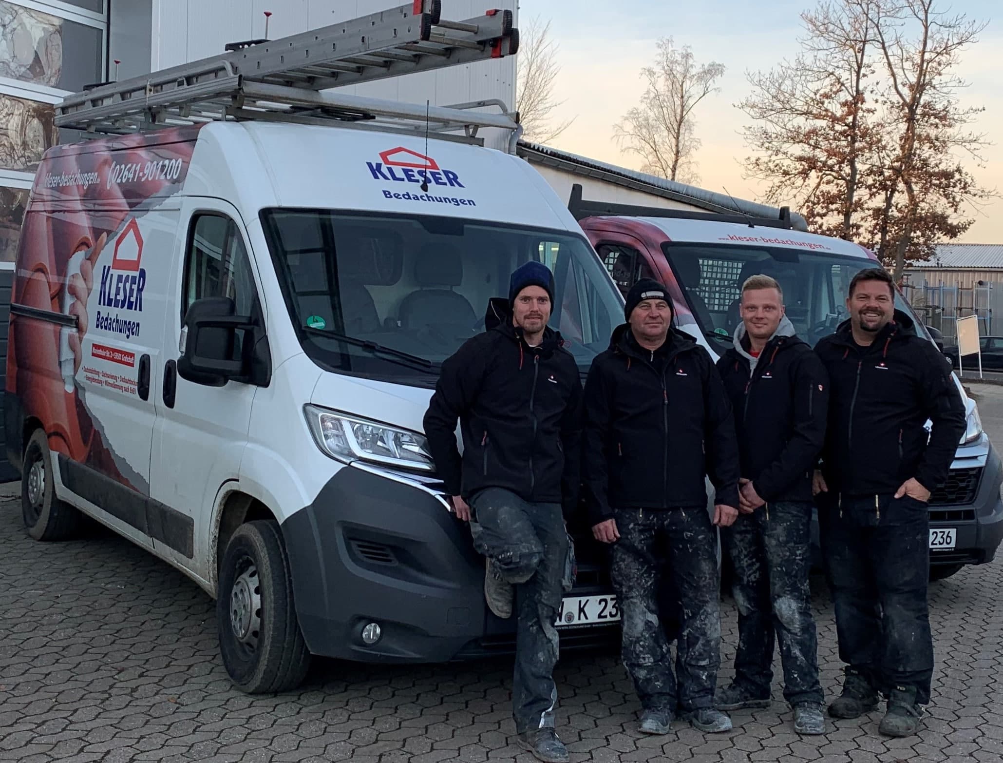 Das Team von Kleser Bedachungen vor den Firmenfahrzeugen in Grafschaft